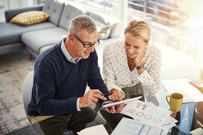 Shot of a mature couple using a digital tablet while going through paperwork at home