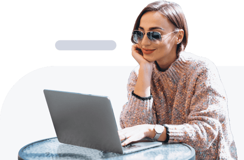 Woman sitting at a table while typing on her laptop