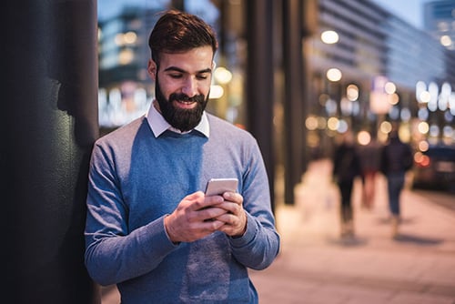 Man smiling while texting