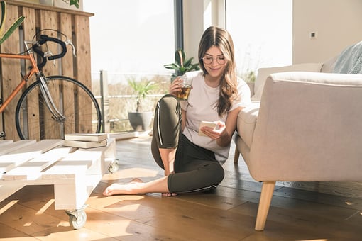 woman sitting on floor looking at phone