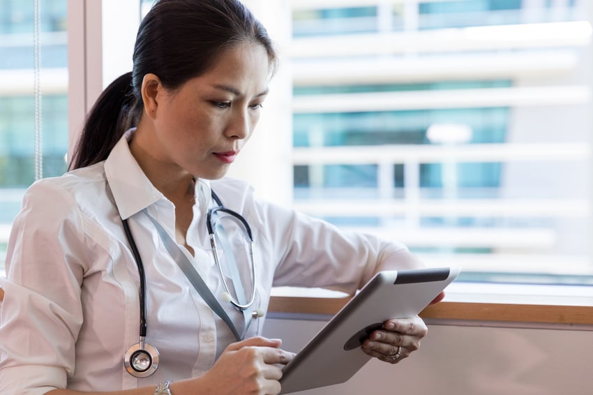 Doctor checking tablet for patient information