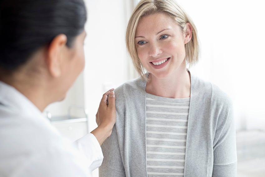 758310051 Female doctor with hand on patients shoulder.