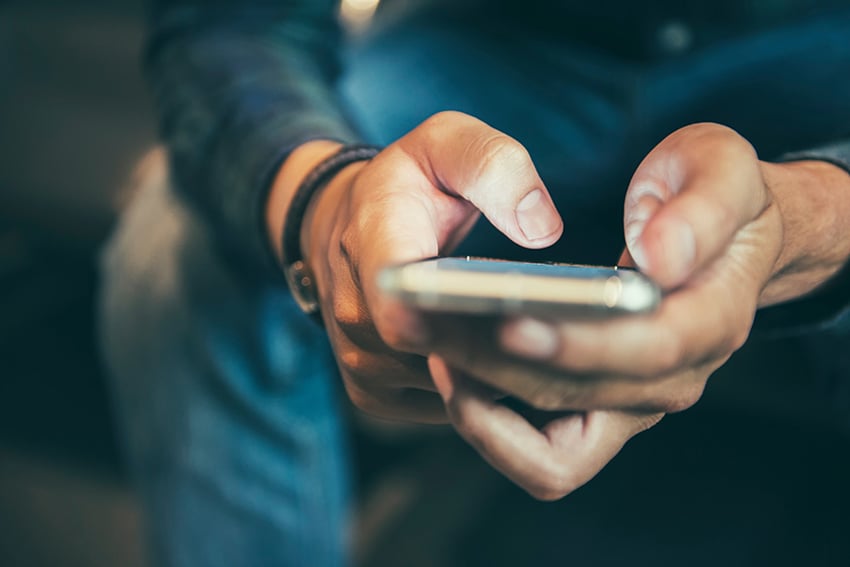938786704 Person texting on mobile phone
