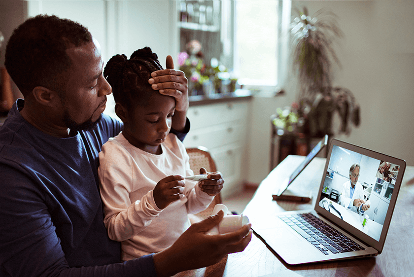 A father consulting with a doctor over video with daughter