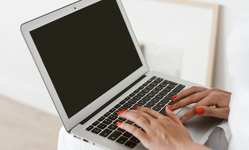 Open laptop with stethoscope, reading glasses and a closed chart